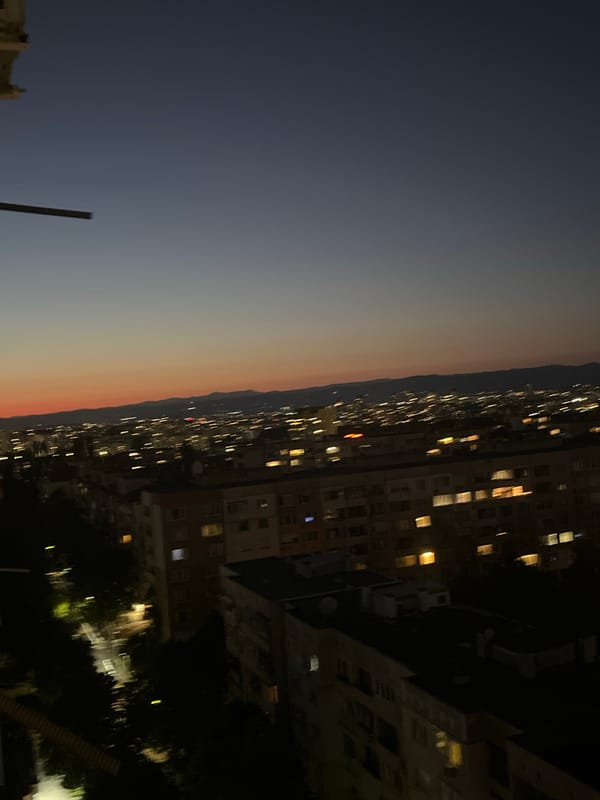 City skyline at dusk, blue-to-orange sky over silhouetted buildings