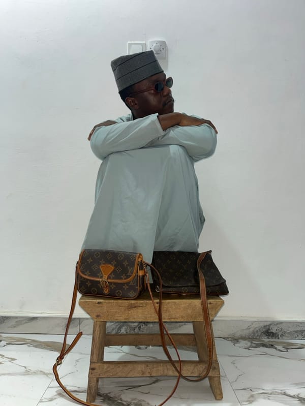 Man poses with luxury bags, reads magazines in Ghana