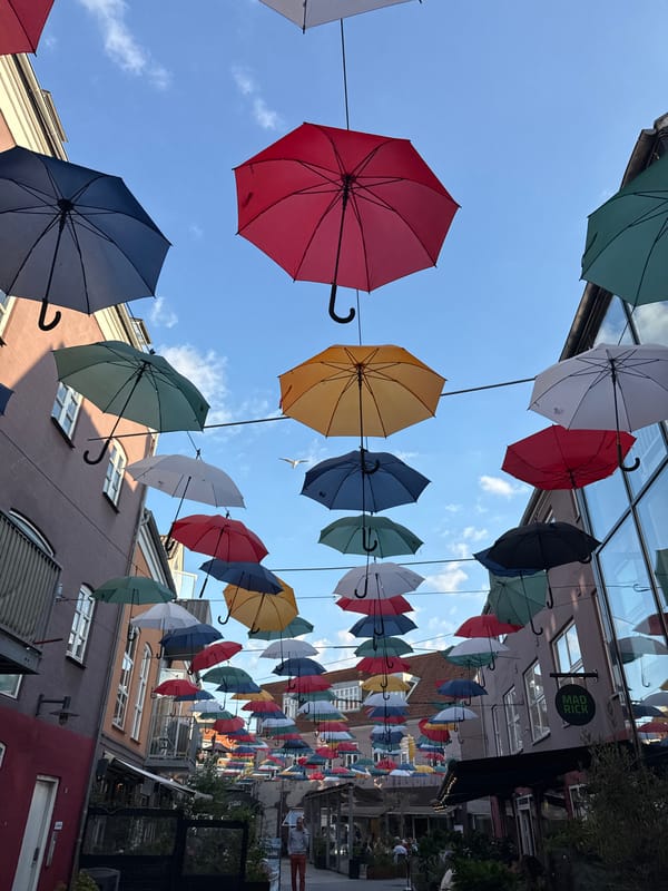 Colorful umbrella canopy installation lines a Vejle street