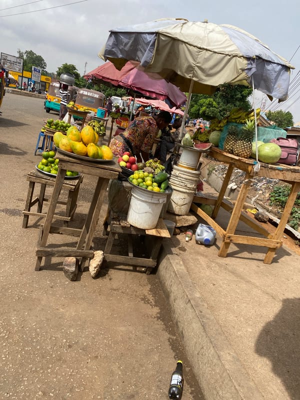 Street vendors sell fresh produce at Bukuru market