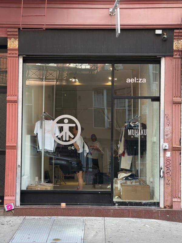 Man installs storefront decals on NYC retail location