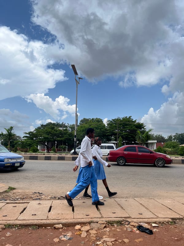 Busy afternoon streets in Jos, Nigeria, with school groups and street traffic