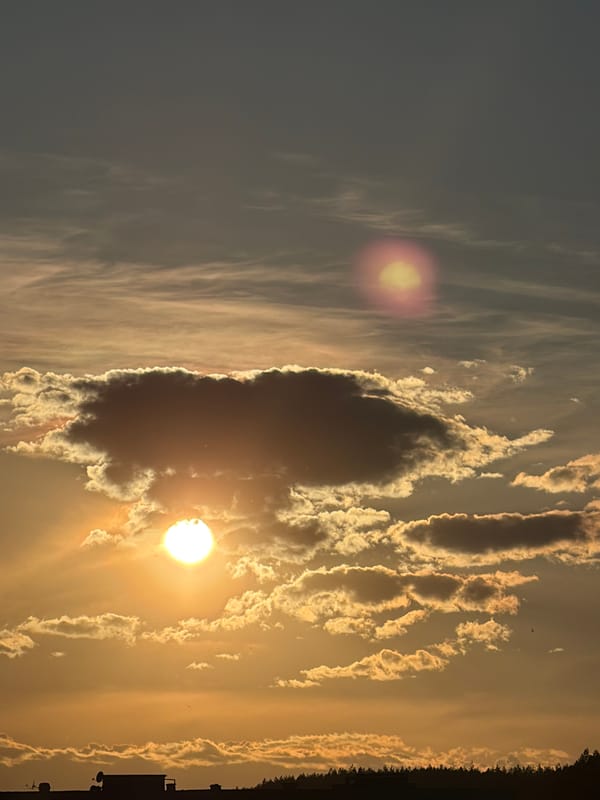 Sun breaks through dark clouds in afternoon sky