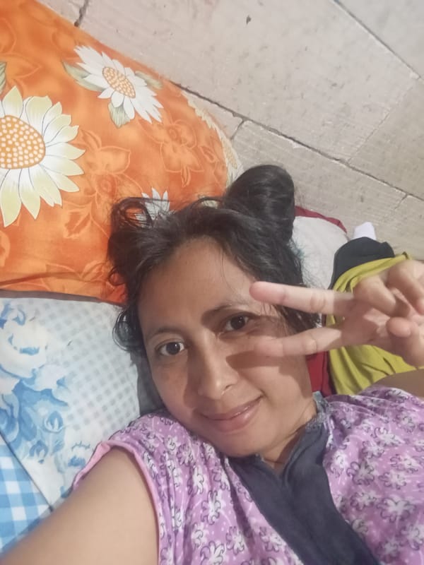 Woman makes peace sign while resting in Baron, Indonesia