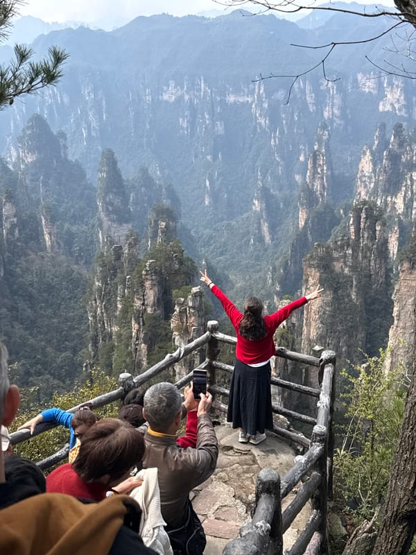 Tourists photograph Zhangjiajie's sandstone pillars at scenic viewpoints
