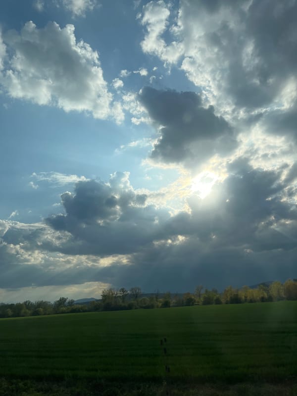 Sunbeams pierce cloudy sky over Bulgarian countryside