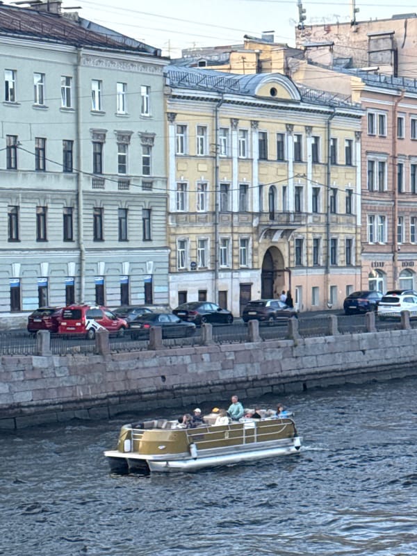 Tourist takes selfies during evening canal boat tour in Saint Petersburg