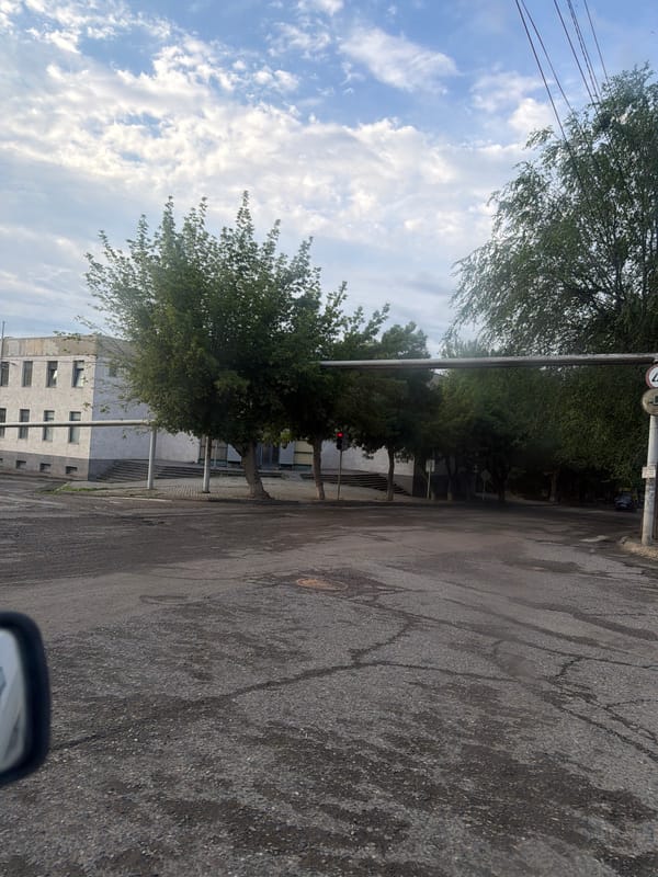 Street corner and mountain terrain under cloudy skies