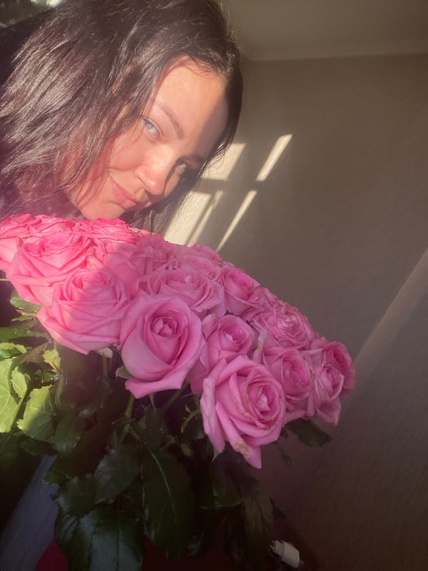 Woman receives pink roses in early morning Sochi scene