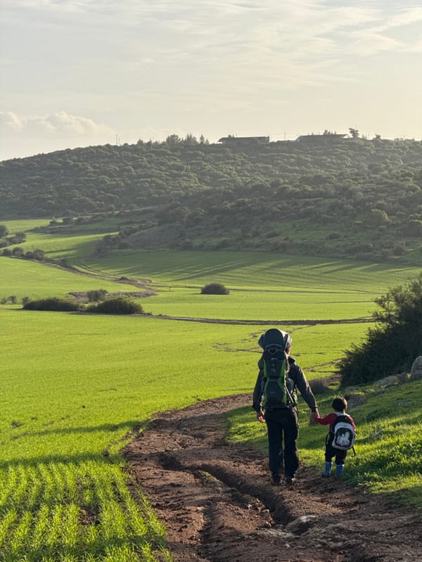 Family group walks muddy farm path in Israeli countryside