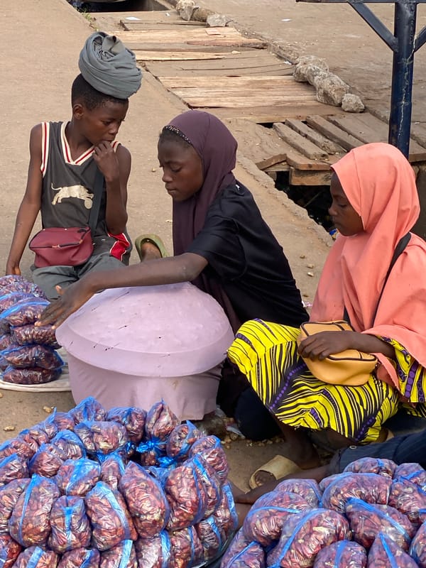 Street vendors and shoppers fill a Sabon Tasha market morning