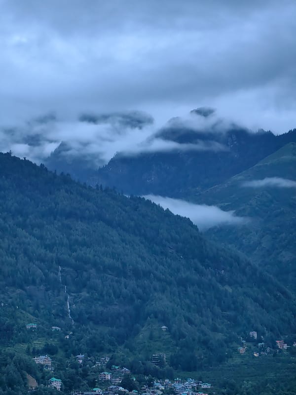 Vashisht village wrapped in mountain mist on an overcast evening
