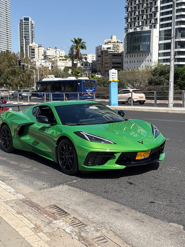 Green sports car parked, woman takes elevator selfie in Tel Aviv area