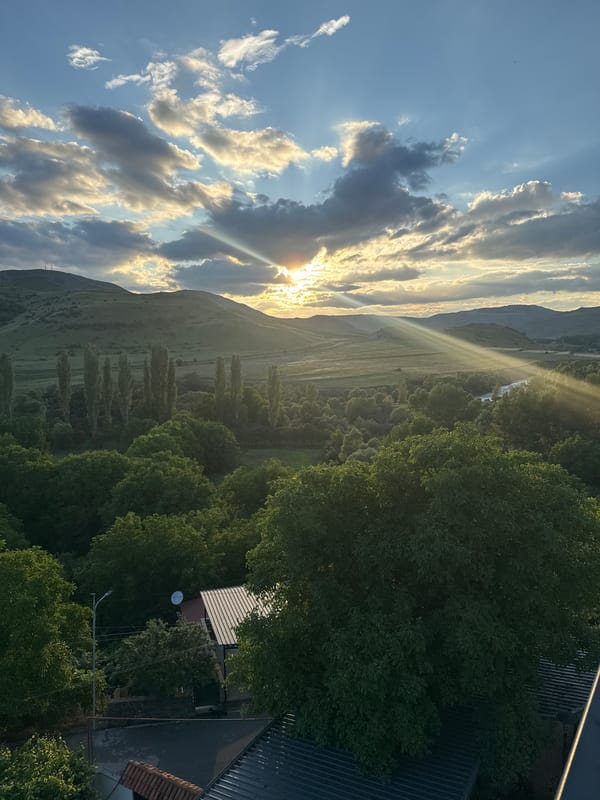 Golden hour light breaks over Aspindza's rooftops and stormy sky