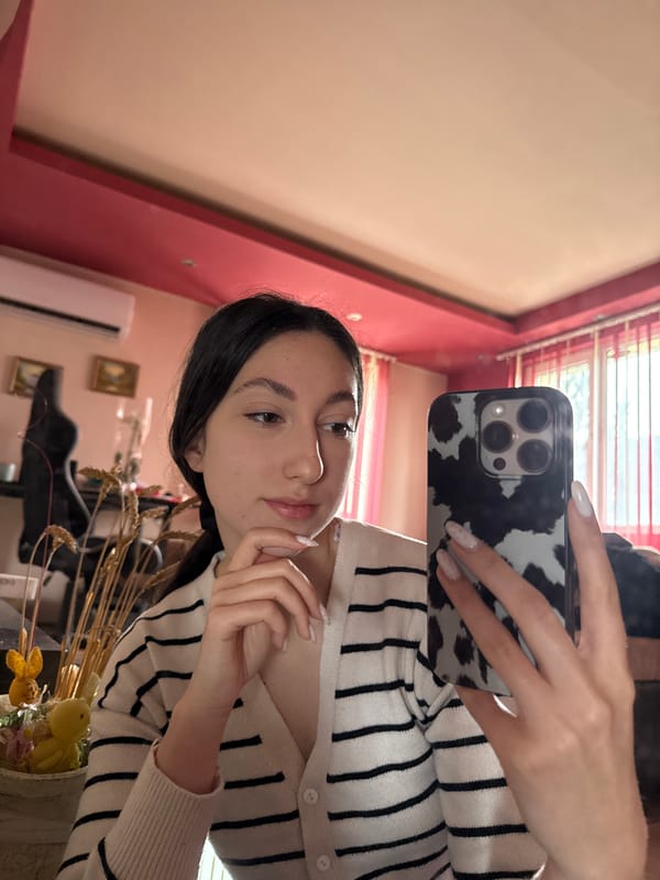 Woman takes mirror selfie in striped cardigan, Bulgaria