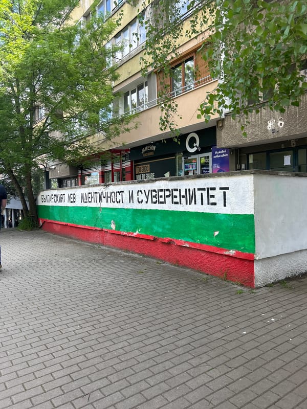 Building displays Bulgarian flag colors with Cyrillic text in Sofia
