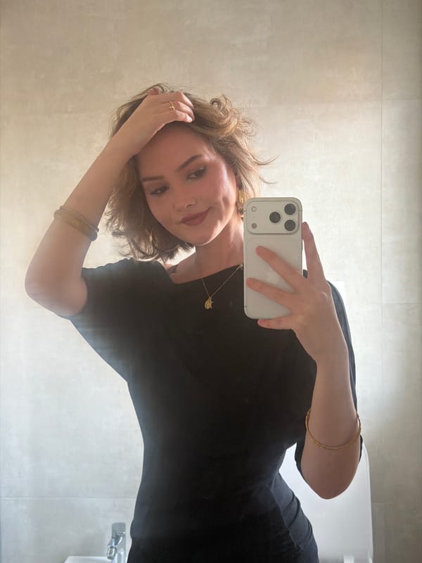 Woman takes bathroom selfie in Milan wearing black dress