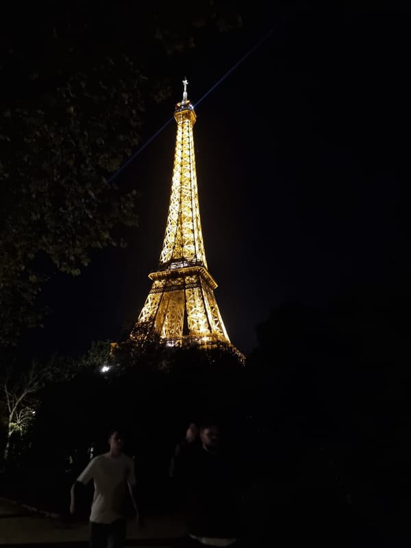 Eiffel Tower glows golden with blue beam Friday evening