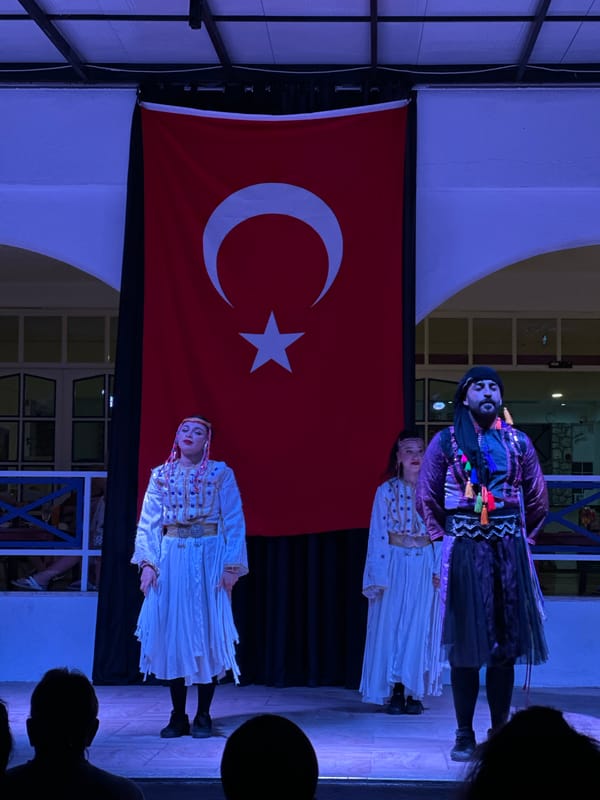 Traditional folk dancers perform in Fethiye against Turkish flag backdrop