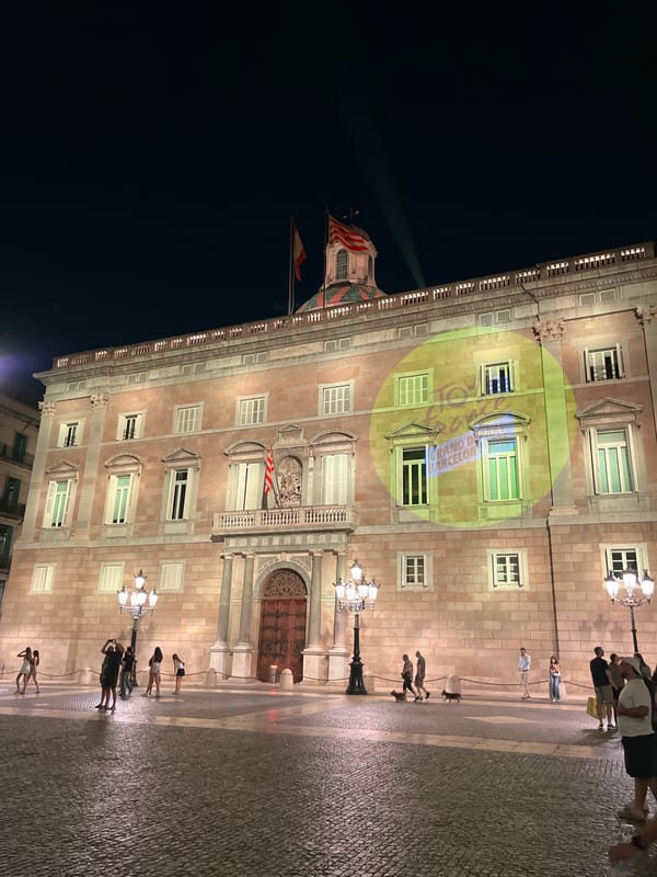 Yellow graphic projected onto illuminated Barcelona building at night