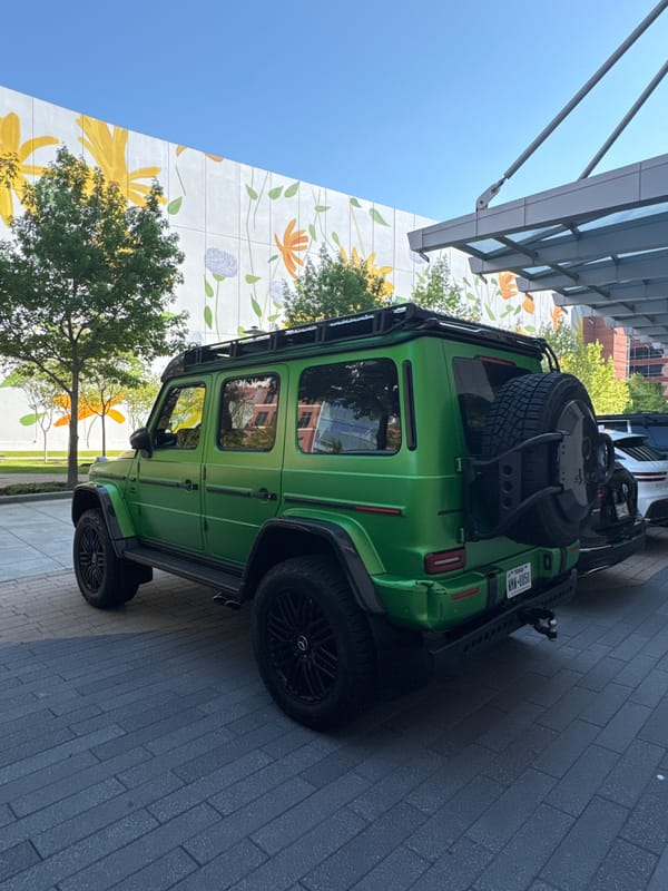 Lime-green G-Wagon spotted on brick walkway near colorful mural