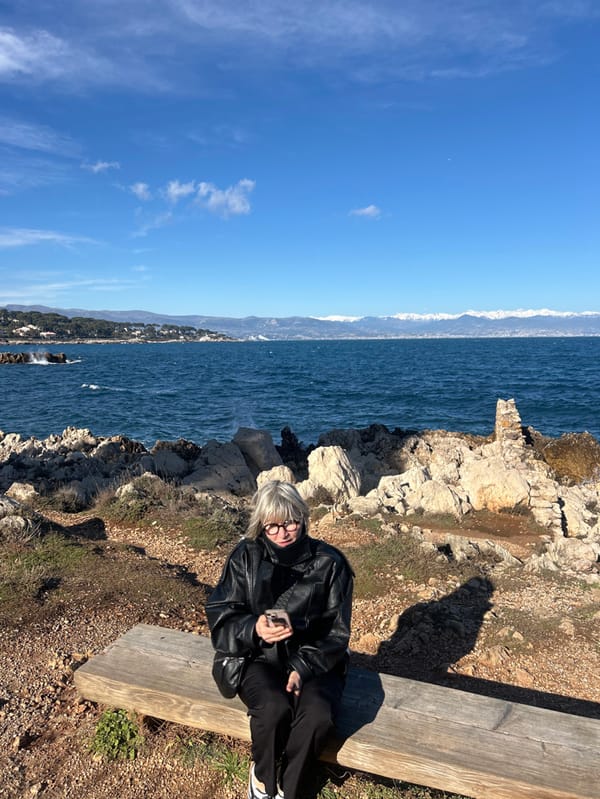 Woman photographs scenic coastal walk in Antibes, France