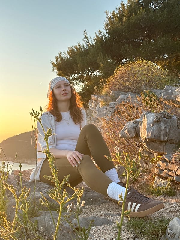 Person exercises, rests on rocks in Montenegro coastal area