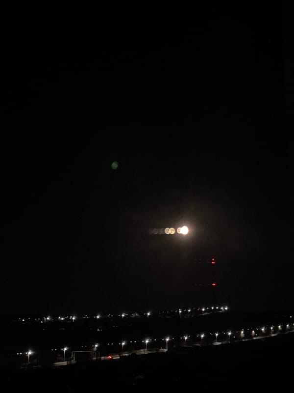 Moonlit evening scene captured along illuminated waterfront in Chaikovsky