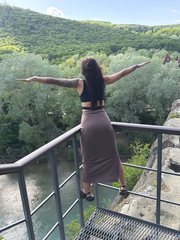 Woman poses on viewing platform overlooking valley in Russia