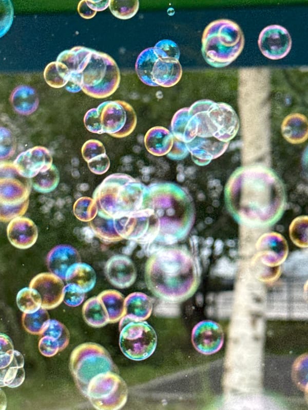 Soap bubbles drift across a sunny Krasnoyarsk playground
