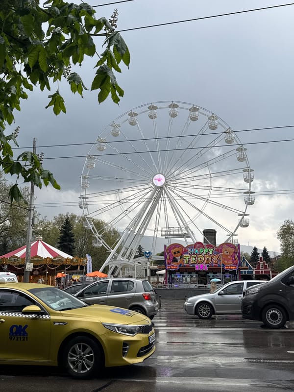 White Ferris wheel operates under grey skies in Sofia