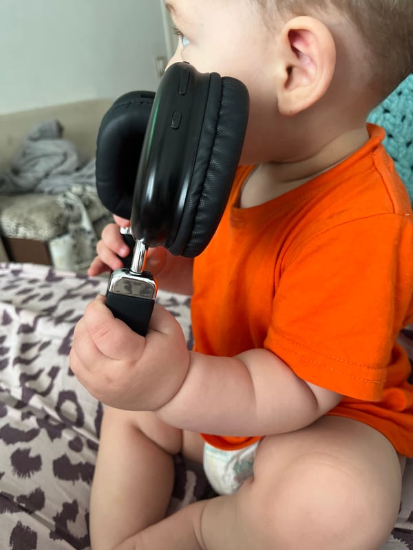 Toddler explores headphones during a lazy morning at home