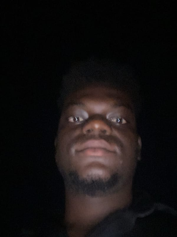 Low-light portrait of bearded man captured in darkness