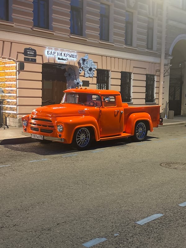 Orange vintage truck spotted near Russian rooftop bar building