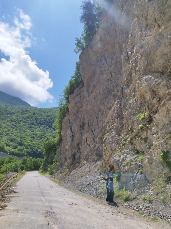 Flood-damaged road and muddy river in mountainous Kiri, Russia