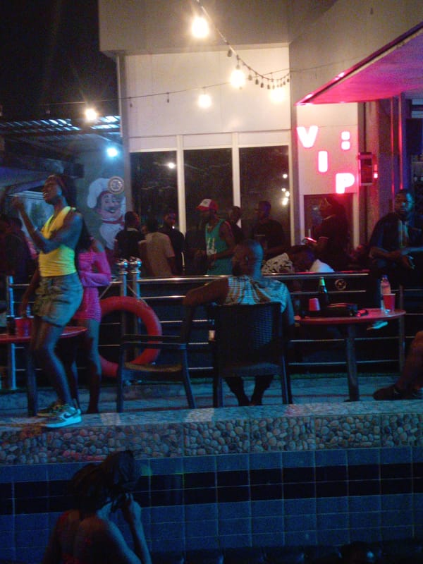 Late-night social gathering at outdoor bar with dancing patrons