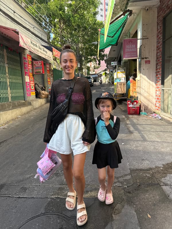 Street-level Nha Trang: sculptures, food stalls, and tour vehicles