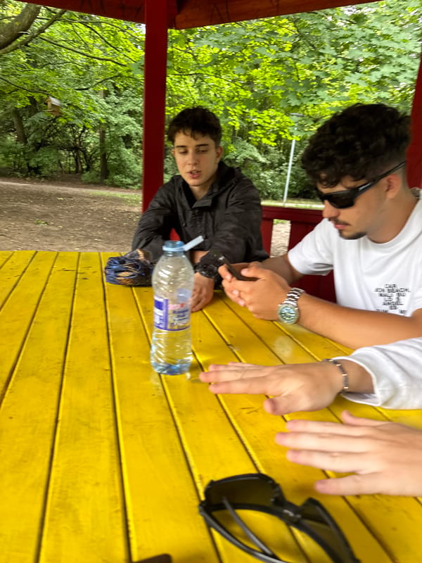 Three people meet at yellow table in Sofia park
