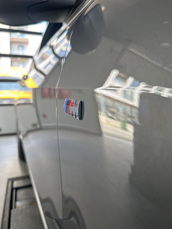 Car badge and a flavored vitamin drink, up close