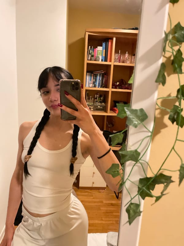 Woman takes mirror selfie in bedroom in Cassano Magnago
