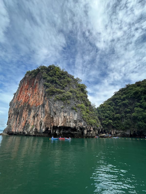 Rugged limestone island cliff rising from green Andaman waters
