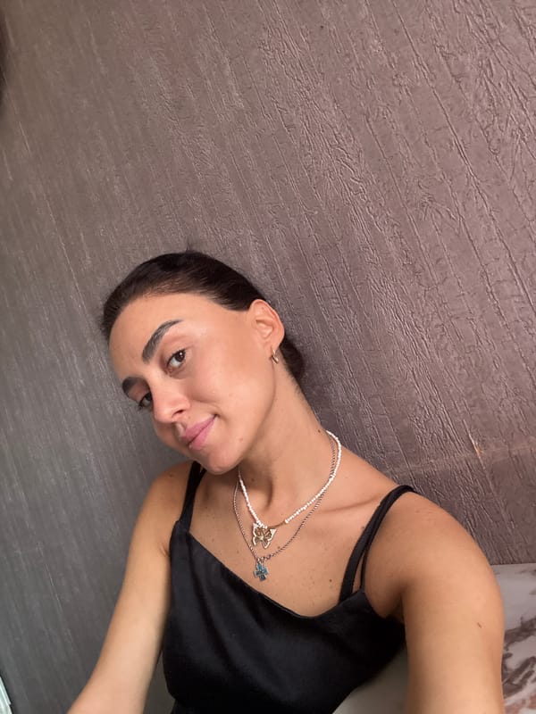 Layered necklaces and a relaxed pose, indoors in Tbilisi