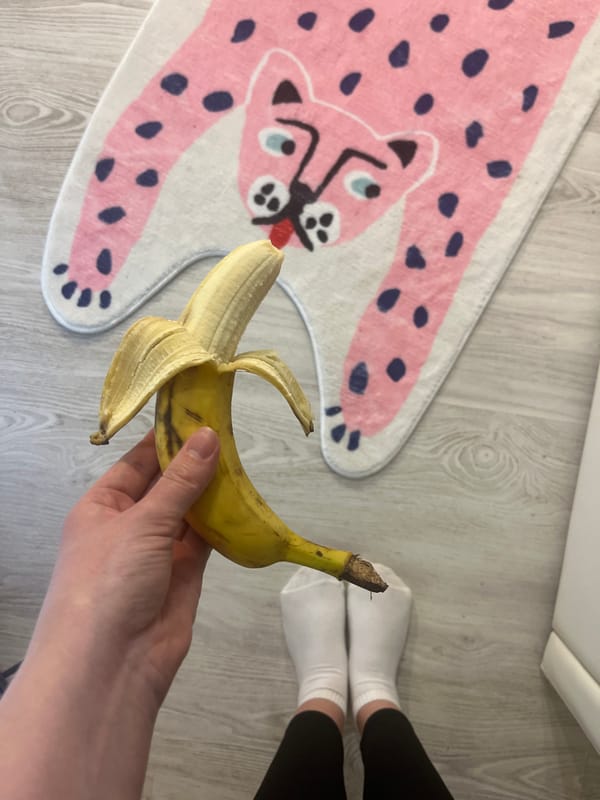 Person holds peeled banana over wooden floor in Sevastopol