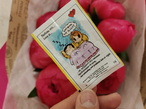 Love Is candy wrappers photographed with pink peonies