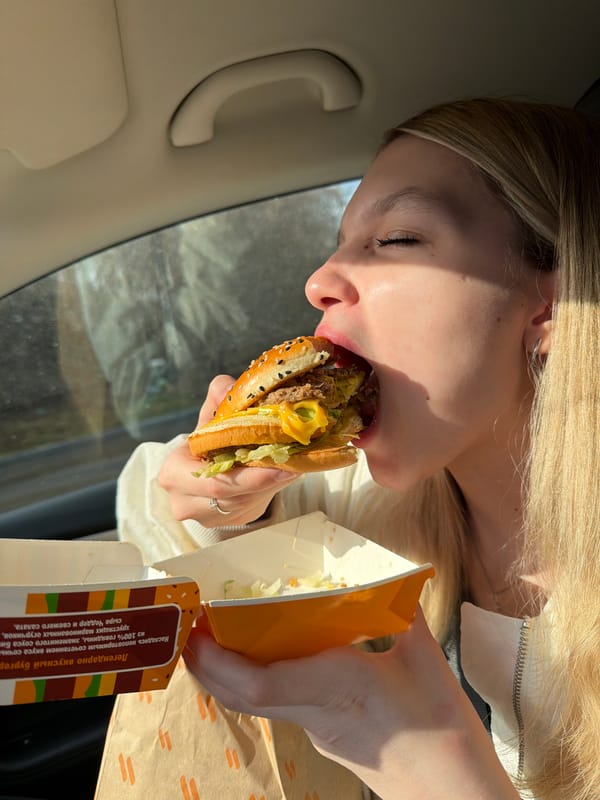 Woman eats hamburger in car in Yekaterinburg