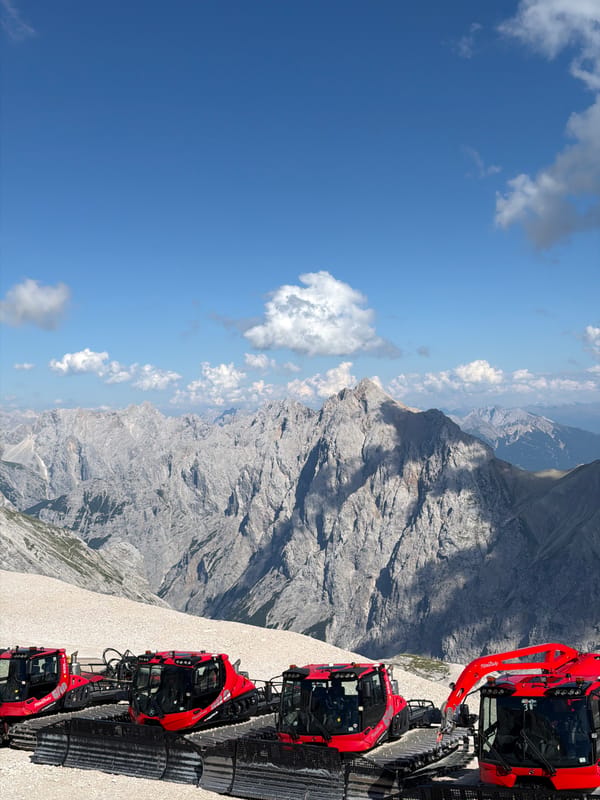 Summer day in the Bavarian Alps, snow groomers and a prop plane