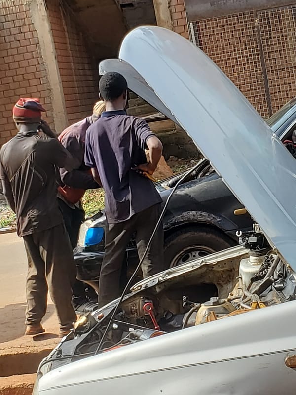 Roadside mechanics and daily life on a Bukuru street