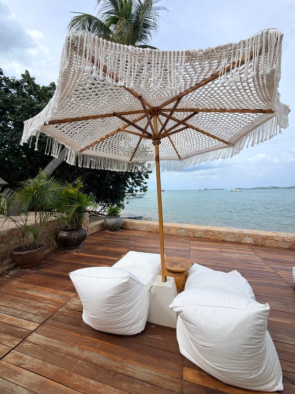 Laid-back Ko Samui beach setup with boats, loungers, and tropical pavilions
