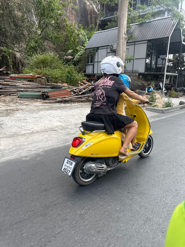 Two riders spotted on yellow Vespa in Thai coastal town