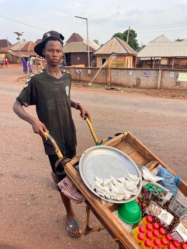 Man in black clothing stands on red road in Apunu
